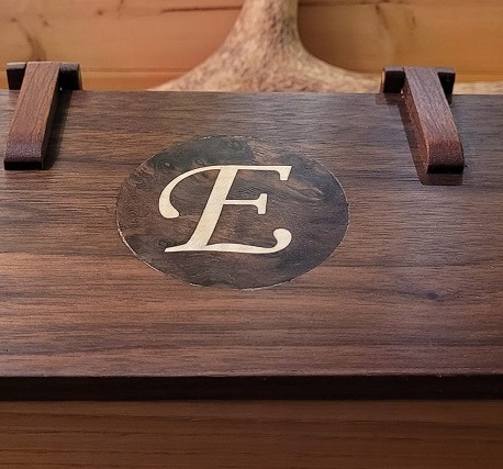 rectangular box with 'E' initial and wooden hinges